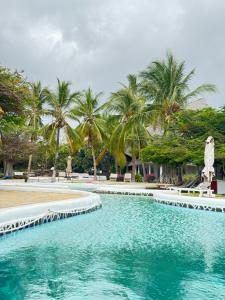 ein Swimmingpool mit Palmen im Hintergrund in der Unterkunft Luxx suites 316 in Malindi