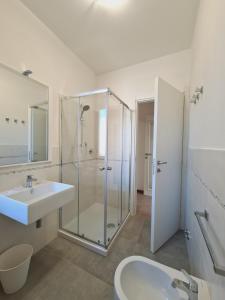a bathroom with a glass shower and a sink at Villaggio Mietta in Castiglioncello