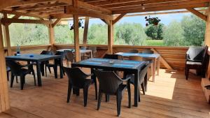 ein Restaurant mit Tischen und Stühlen auf einer Holzterrasse in der Unterkunft Timona in Dunavăţu de Jos