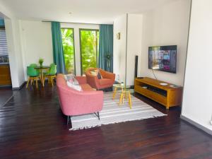 a living room with two chairs and a tv at Appartement avec jardin Cap Malheureux in Cap Malheureux
