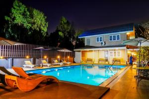 a swimming pool in front of a house at night at Luna Hut Resort in Hua Hin +21 photos