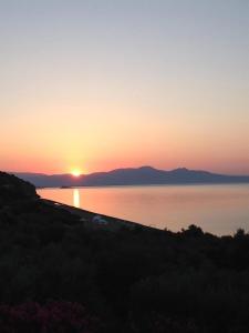 a sunset over a body of water with the sun setting at The Olive Yard in Gythio