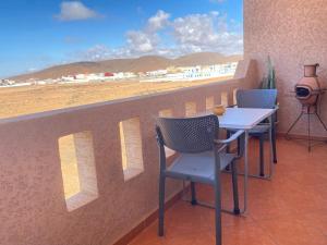 een tafel en stoelen op een balkon met uitzicht op het strand bij Tawada in Mirleft