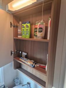 a bathroom with a shelf with products on it at Durdlee Door, D27, Main Rd, West Lulworth, Wareham BH20 5PU in West Lulworth +71 photos