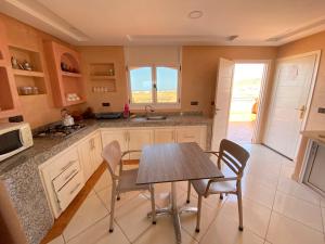een keuken met een tafel en stoelen en een wastafel bij Tawada in Mirleft +25 foto's