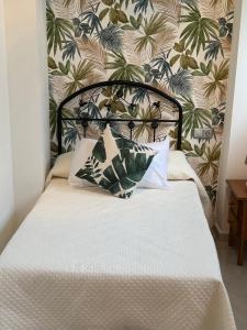 a bed with two pillows in front of a wall at Apartamento Elegance La Cala Benidorm in Benidorm +42 photos