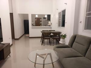 a living room with a couch and a glass table at บ้านสวนสุรัชฎา ปาย in Kampong Huaibū