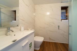a bathroom with a white sink and a toilet at Cascais Sun Terrace Casino Estoril Apartment in Estoril +26 photos