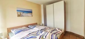 a bedroom with a bed and a painting on the wall at Ostseeresidenz - Whg 17 in Groß Kirr