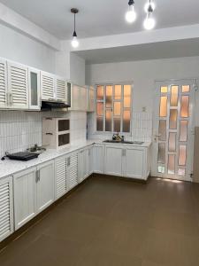 a large white kitchen with white cabinets and appliances at Nhà Trong Ngõ Homestay and Studio in My Tho