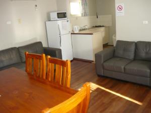 a kitchen and living room with a table and a couch at Albany Apartments in Albany