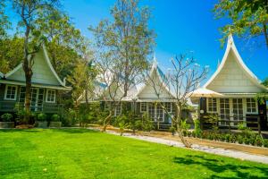 a house with a green yard and trees at Luna Hut Resort in Hua Hin