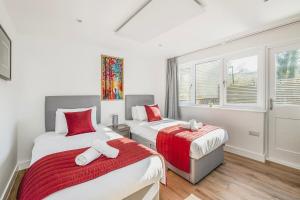 a bedroom with two beds and a window at Laurel Lodge - Stylish Two Bed & Free Parking in Box