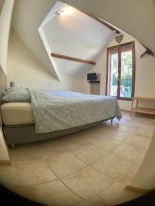 a bedroom with a bed and a large window at Beauval Chambre in Seigy +8 photos