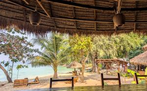 a view of the beach from a restaurant with chairs and tables at KAMAKU Bungalows - Sunset Beach in Koh Rong Sanloem +39 photos