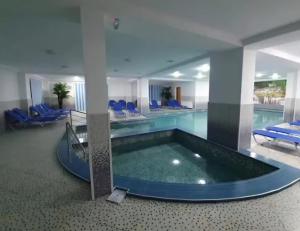 een groot zwembad met een groot bad in een gebouw bij Poiana Bucovineana in Poiana Negrii +21 foto's