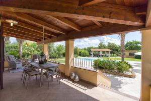 アルゲーロにあるVilla Paradiso with swimming pool large garden and tennis courtのパティオ(テーブル、椅子付)、プールが備わります。