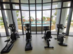 a room with four exercise equipment in front of a window at Almas Couple Urban Retreat Puteri Harbour BySTAY in Iskandar Puteri