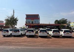 a group of white cars parked in a parking lot at Hotel New Kesar Palace in Agolai