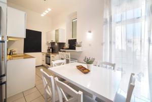 een keuken en eetkamer met een witte tafel en stoelen bij Golden Star in Zagreb