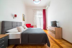 a bedroom with a bed and a television in it at Golden Star Apartment - Spacious City Center Stay in Zagreb
