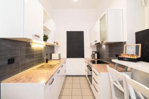 een keuken met witte kasten en witte apparaten bij Golden Star in Zagreb