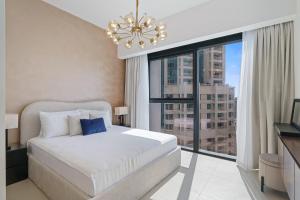 a bedroom with a bed and a large window at Stylish 1 Br In Downtown Near Burj Khalifa in Dubai
