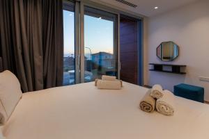 une chambre avec un grand lit blanc avec des serviettes dessus dans l'établissement Napa Hills Seaview Villas, à Ayia Napa 113 autres photos