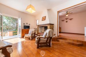 Una sala de estar con chimenea y sillas. en Domus Gina, en Solanas