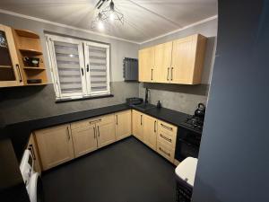 una piccola cucina con mobili in legno e una finestra di Apartament Przyjazny a Żywiec
