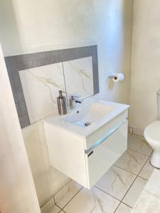 a white bathroom with a sink and a toilet at 2 Bedroom Cottage sleeps maximum 4 Buhlebendalo in Benoni