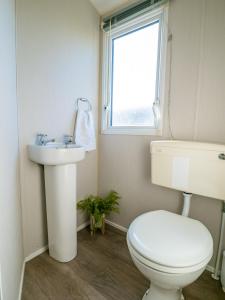 ein Badezimmer mit Toilette und Waschbecken und einem Fenster in der Unterkunft North Shore Skegness, 3 Bedroom 2 Bathroom Sleeps 8 in Skegness