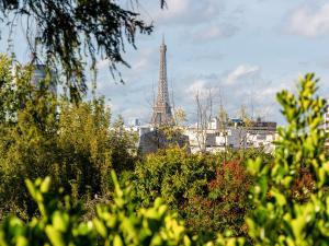 widok na wieżę Eiffel z parku w obiekcie Domaine de la Reine Margot Paris-Issy - MGallery Collection w mieście Issy-les-Moulineaux