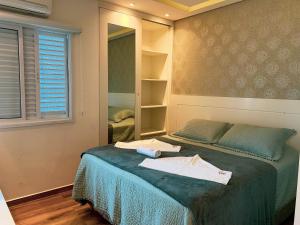 Voodi või voodid majutusasutuse Apto Alto Padrão C/ Suíte, SmarTV, Wi-FI e Piscina toas +21 fotot