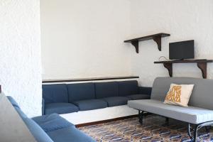 a living room with a blue couch and a tv at Numana, villa singola con giardino e vista mare N111 in Numana
