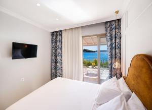 ein Schlafzimmer mit Bett und Meerblick in der Unterkunft Eva Beach Hotel Lefkada in Nydri