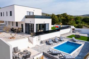 eine Luftansicht auf ein weißes Haus mit einem Pool in der Unterkunft Villa Vista Adriatica in Donji Seget