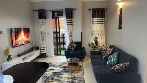 a living room with two blue couches and a fireplace at Summer villas in Kampala