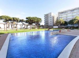 a large blue swimming pool in a city at Seafront Apartment - Costa Brava in Blanes