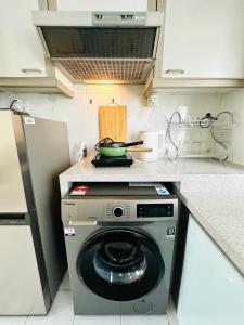 a kitchen with a washing machine with a pot on top at Costa Mahkota - 3 min to Mahkota, 4pax, 1car park in Melaka