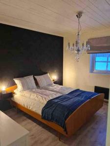 una camera da letto con un letto grande e un lampadario di Spacious cottage in Storvallen, Storlien, 2 Bedrooms a Storlien