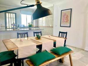 un comedor con una mesa con cojines verdes en Chez Juan By Solymar Holiday, en Torre del Mar 20 fotos más