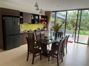 a kitchen with a table with chairs and a refrigerator at Gia Hân Villa in Cam Thanh