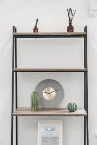 un estante con un reloj y un cactus en él en Prime Central London Residences, en Londres
