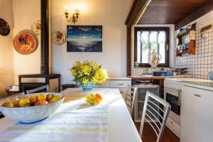 a kitchen with a table with a bowl of fruit on it at Casa Country in Capoliveri +28 photos