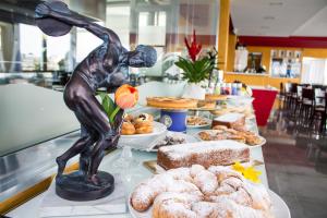 a table with a statue of a person eating pastries at Hotel del Sole in Pompei