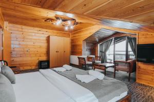 a bedroom with a large bed in a room with wooden walls at Inan Kardesler Hotel in Uzungöl