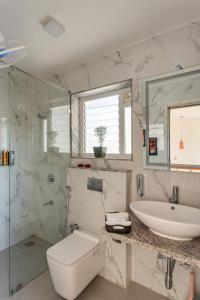a bathroom with a sink and a toilet and a shower at Alaya Stays Cavalo Marinho - 3 BHK Boho Retreat with Private Pool & Terrace in Camorlim +21 photos