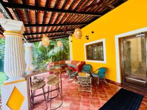 a room with chairs and a table and a yellow wall at Island Pool Villa I Pvt Pool I Cook I Staff I WIFI in Vainguinim