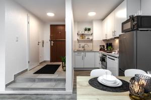 Una cocina con gabinetes blancos y un refrigerador. en Appartement Ohechaussee, en Norderstedt 3 fotos más